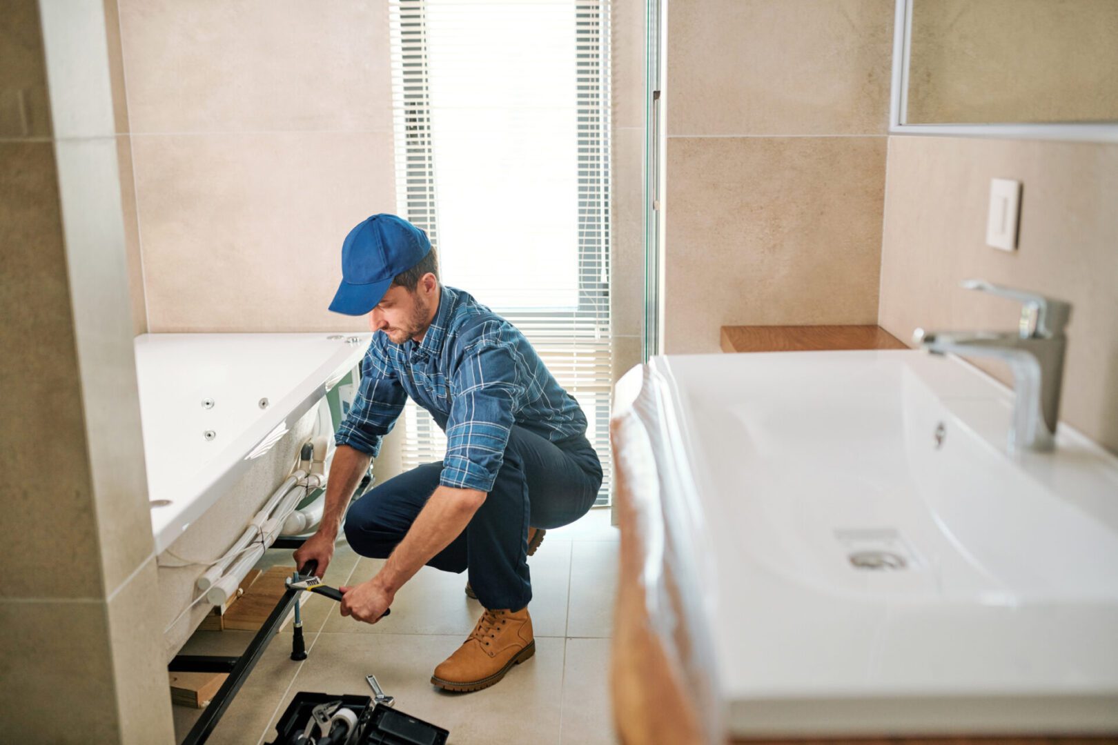 Plumber fixing bathroom sink pipes.