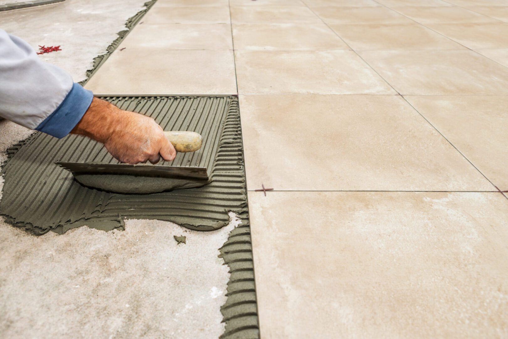 Hand applying mortar for tile installation.