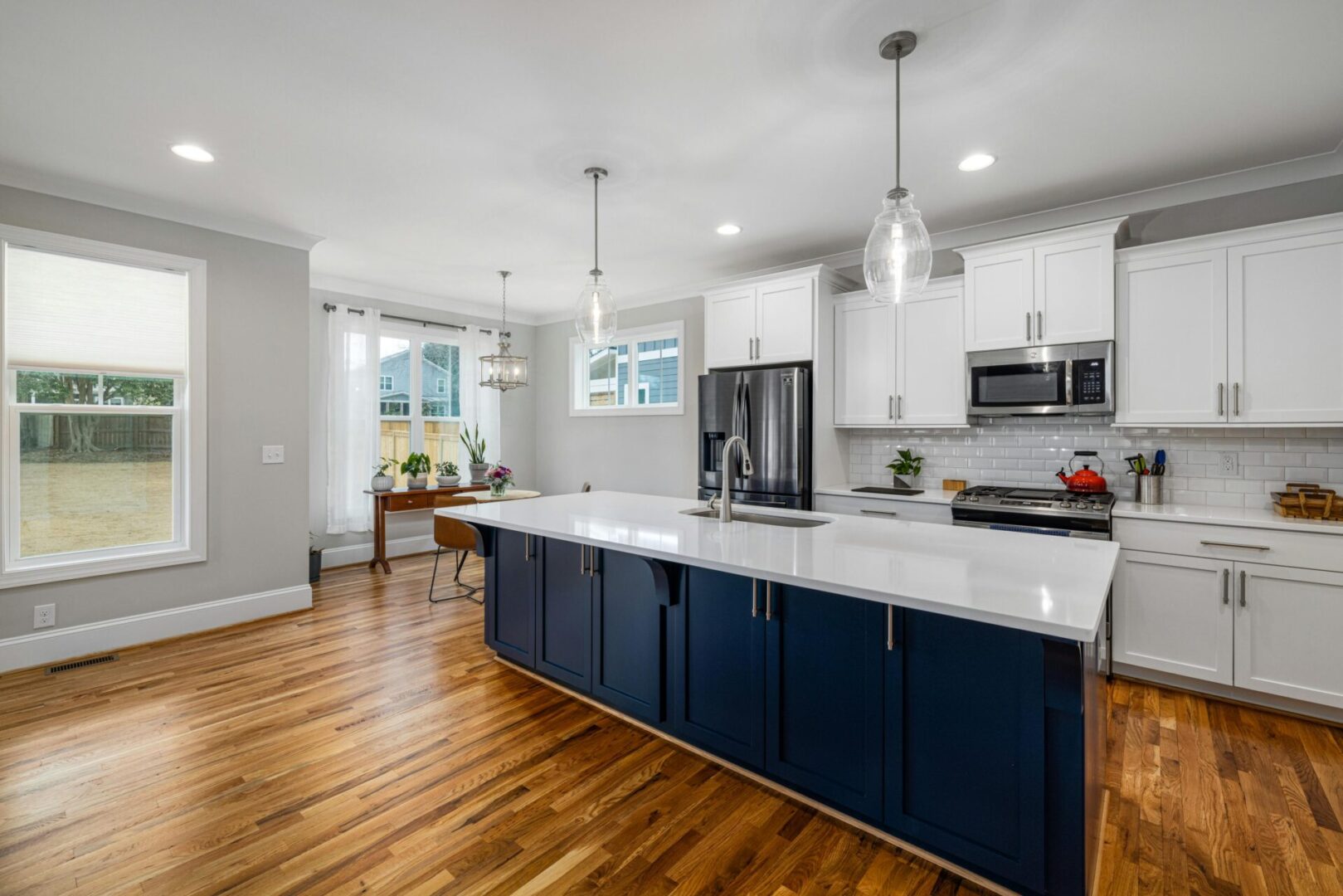 Modern kitchen with island and hardwood flooring.