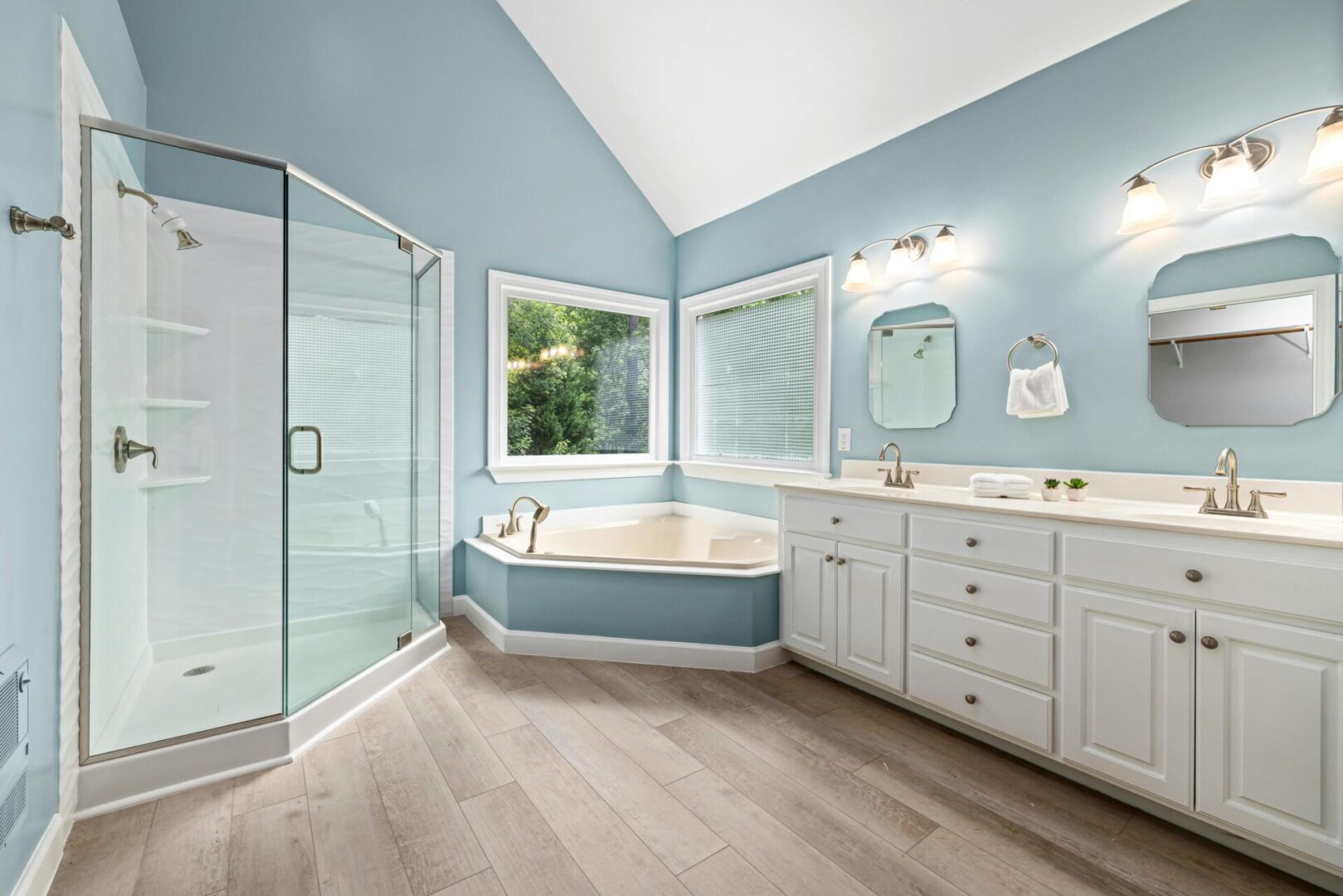 Spacious bathroom with bathtub and glass shower.