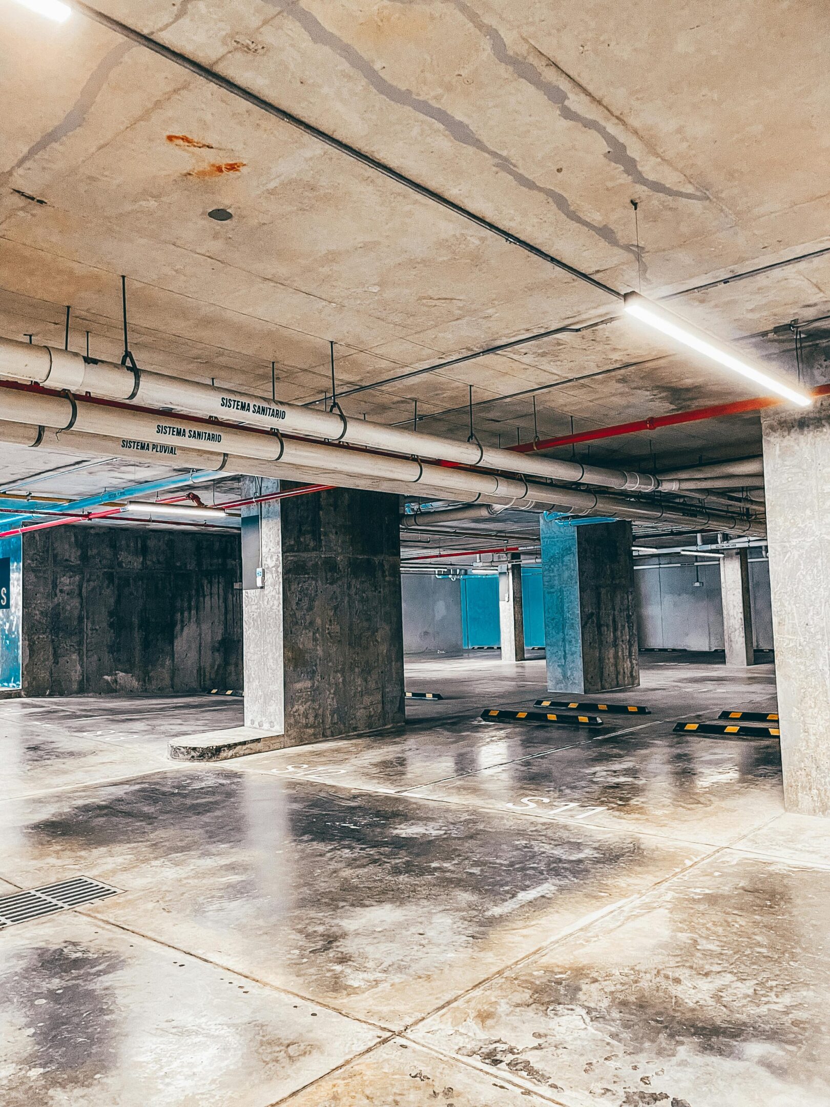 Empty underground parking garage with concrete pillars.